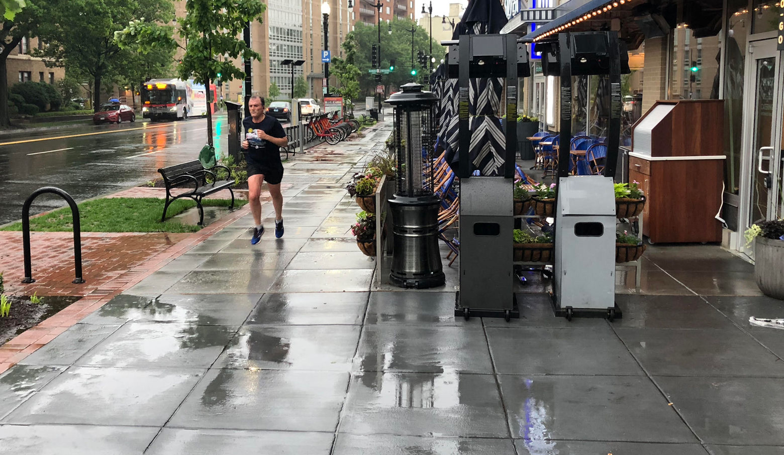 A runner braves the rain along Wisconsin Avenue in Washington, D.C. on Friday. (WTOP/Dan Friedell)