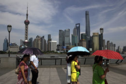 People walk on the Bund against buildings in Pudong, China's financial and commercial hub, in Shanghai, China Friday, May 22, 2015. Negotiators from 57 governments completed work Friday on a charter for a Chinese-led Asian regional bank that is to be signed in late June, the Chinese finance ministry said. (AP Photo/Paul Traynor)