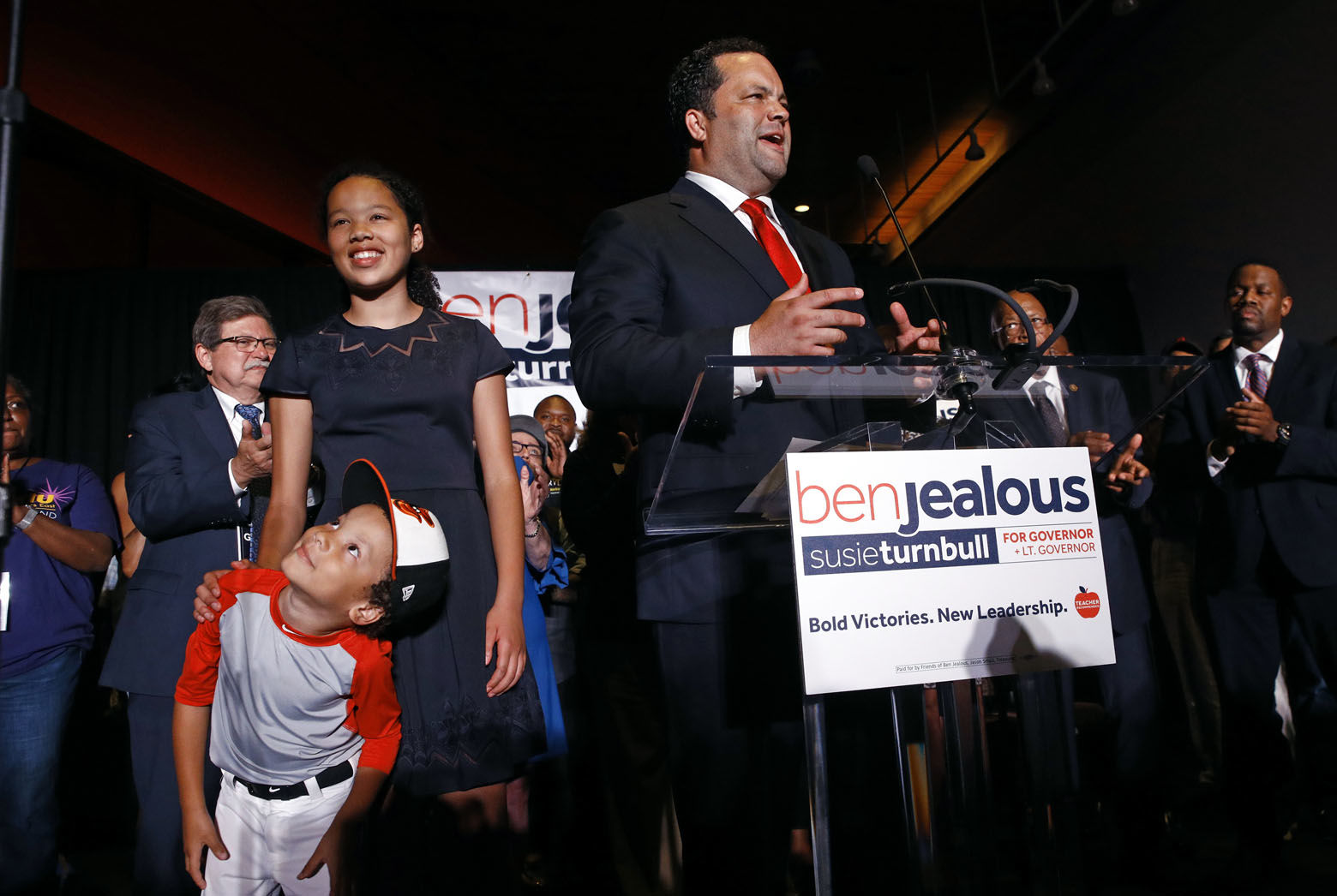 Maryland Democratic gubernatorial candidate Ben Jealous, right, addresses supporters as his son Jack, left, looks at his reflection in a teleprompter screen at an election night party, Tuesday, June 26, 2018, in Baltimore. Also pictured is Jealous' daughter, Morgan, second from left. Jealous won the Democratic nomination for governor in Maryland, setting up a battle against popular incumbent Republican Gov. Larry Hogan in the fall. (AP Photo/Patrick Semansky)