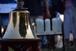 A bell and candles — with images of the five victims murdered at the Capital Gazette in Annapolis, Maryland — burn during a Friday prayer vigil at the Westfield Annapolis Mall. (Courtesy/Bethany Swain)