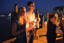 Summer Bedard  (Left) holds a candle and newspaper Friday night at a vigil in downtown Annapolis for victims killed in a shooting at the Capital Gazette in Annapolis, Maryland. (Courtesy/Bethany Swain)