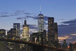 In this Aug. 19, 2016 photo, the lower Manhattan skyline, including One World Trade Center and the Brooklyn Bridge, are shown in New York. Construction cranes continue working on top of 3 World Trade Center. Fifteen years after the Sept. 11th attacks, downtown New York has been reborn, not just with the construction of One World Trade, but with a host of attractions both somber and vibrant, including the 9/11 Memorial and Museum, two retail malls, new hotels and restaurants. (AP Photo/Mark Lennihan)