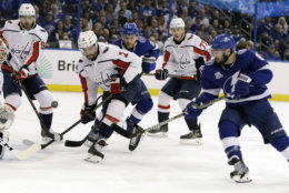 Tampa Bay Lightning center Tyler Johnson (9) gets off a shot on Washington Capitals goaltender Braden Holtby (70) as defenseman Matt Niskanen (2) and center Evgeny Kuznetsov (92) looks for a rebound during the second period of Game 5 of the NHL Eastern Conference finals hockey playoff series Saturday, May 19, 2018, in Tampa, Fla. (AP Photo/Chris O'Meara)