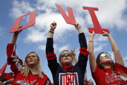 Olivia Spicer, 16, left, Emma Jacobs, 17, and Caroline Schwartz, 18, all of Gainesville, Va., hold up letters spelling the nickname of Washington Capitals' left wing Alex Ovechkin, from Russia, on the National Mall ahead of a victory parade and rally for the Washington Capitals as hockey fans celebrate their winning the Stanley Cup, Tuesday, June 12, 2018, in Washington. (AP Photo/Jacquelyn Martin)