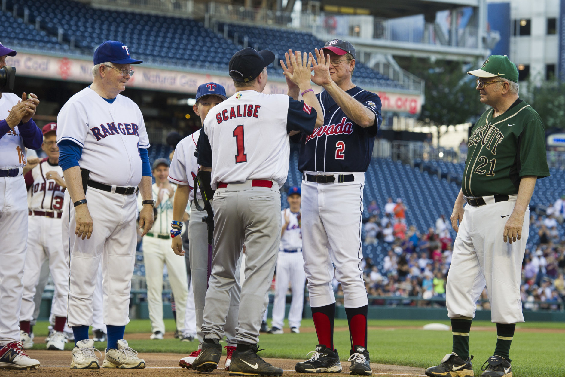 Rep. Steve Scalise, R-Louisiana, center, is announced onto the field at the start of the 57th Congressional Baseball Game at National's Park in Washington, Thursday, June 14, 2018. On June 14, 2017, Scalise and some other Congressional members were victims of a shooting at the baseball field they were practicing on in Alexandria, Va. (AP Photo/Cliff Owen)