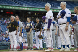 Members of the Democratic and Republican baseball teams stand for the national anthem to start the 57th Congressional Baseball Game at National's Park in Washington, Thursday, June 14, 2018. On June 14, 2017, some Congressional members were victims of a shooting at the baseball field they were practicing on in Alexandria, Va. (AP Photo/Cliff Owen)