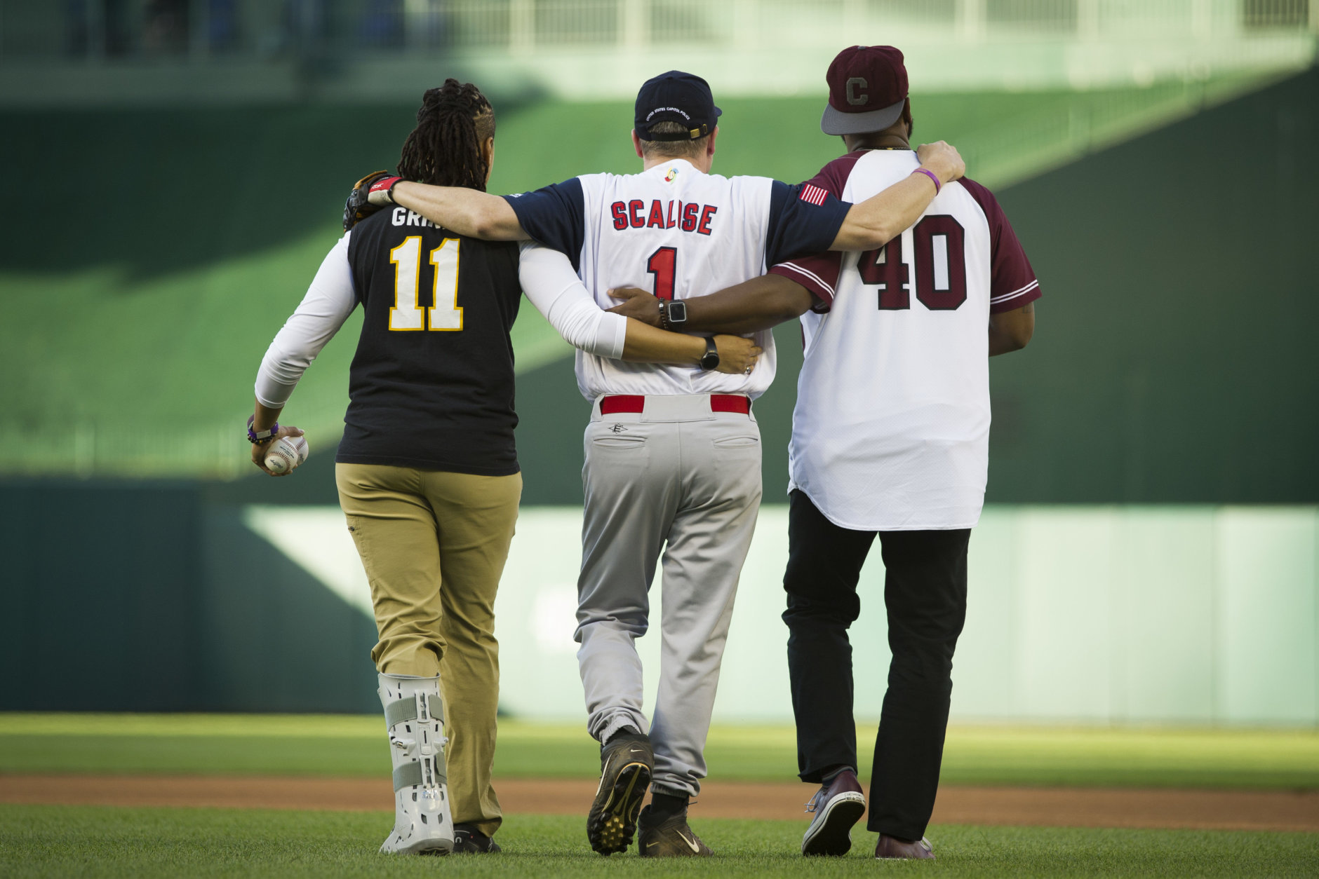 Capitol Police Special Agents Crystal Griner, left, and David Bailey, right, assist U.S. Rep. Steve Scalise to his position at second base at the start of the 57th Congressional Baseball Game at National's Park in Washington, Thursday, June 14, 2018. On June 14, 2017, Scalise was wounded in the leg when he and other Congressional members were the victims of a shooting at the baseball field they were practicing on in Alexandria, Va. (AP Photo/Cliff Owen)