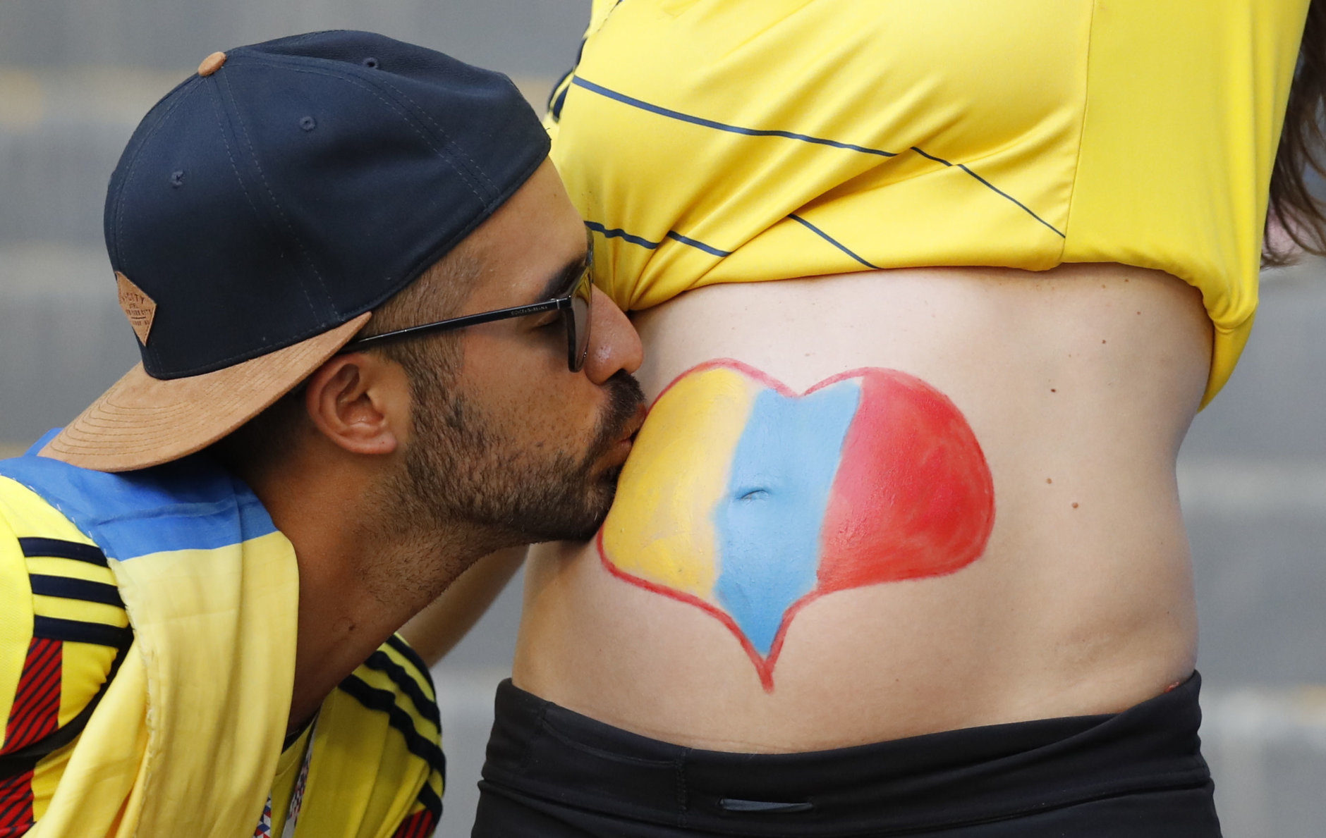 A Columbian supporter kisses the belly of a pregnant woman prior to during the group H match between Senegal and Colombia, at the 2018 soccer World Cup in the Samara Arena in Samara, Russia, Thursday, June 28, 2018. (AP Photo/Efrem Lukatsky)
