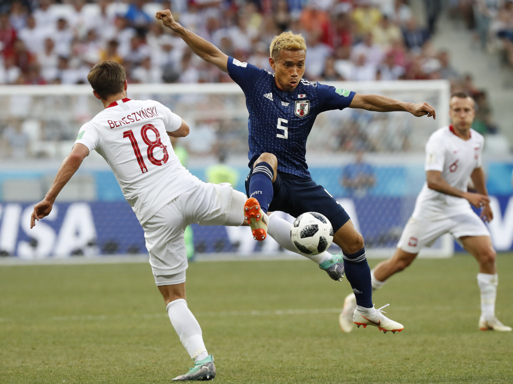 Japan's Yuto Nagatomo, center, and Poland's Bartosz Bereszynski vie for the ball during the group H match between Japan and Poland at the 2018 soccer World Cup at the Volgograd Arena in Volgograd, Russia, Thursday, June 28, 2018. (AP Photo/Eugene Hoshiko)