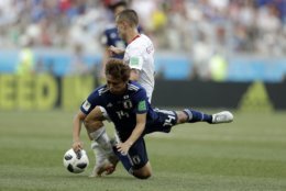 Poland's Jacek Goralski, background, stops Japan's Takashi Inui during the group H match between Japan and Poland at the 2018 soccer World Cup at the Volgograd Arena in Volgograd, Russia, Thursday, June 28, 2018. (AP Photo/Andrew Medichini)
