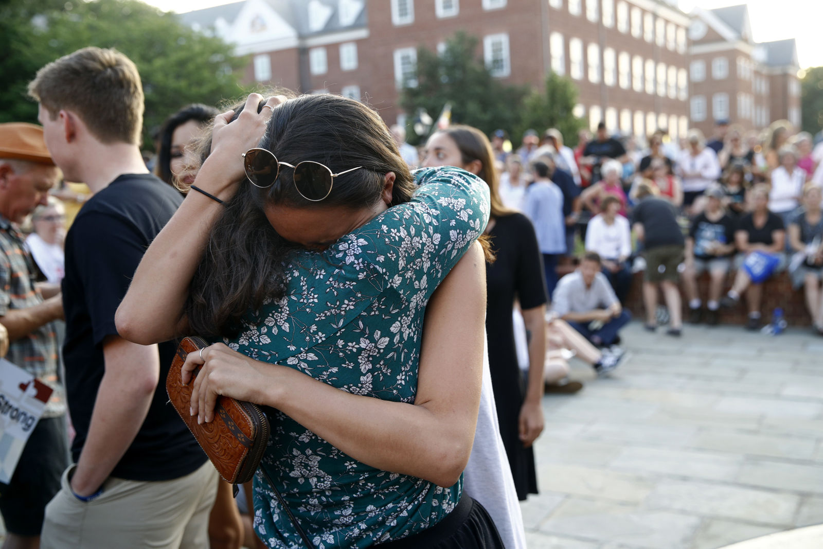 People hug as they gather for a vigil in response to a shooting in the Capital Gazette newsroom, Friday, June 29, 2018, in Annapolis, Md. Prosecutors say Jarrod W. Ramos opened fire Thursday in the newsroom. (AP Photo/Patrick Semansky)