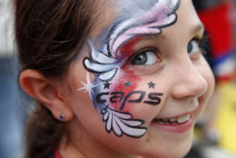Sarah Charapp, 8, of Potomac, Md., shows off her painted face in support of the Washington Capitals, as fans gather to watch Game 3 of the NHL hockey Stanley Cup Final between the Capitals and the Vegas Golden Knights, Saturday, June 2, 2018, in Washington. (AP Photo/Jacquelyn Martin)