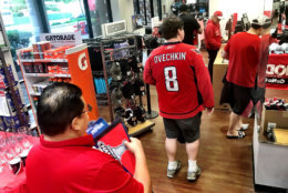 Dozens of sleep-deprived Capitals fans in search of morning-after Stanley Cup gear were standing on the Wisconsin Avenue sidewalk Friday morning, waiting for Modells Sporting Goods to open its doors at 6 a.m. (WTOP/Neal Augenstein)