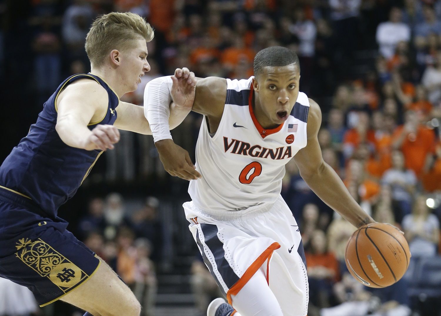 Virginia guard Devon Hall (0) drives past Notre Dame guard Rex Pflueger (0) during the second half of an NCAA college basketball game in Charlottesville, Va., Saturday, March 3, 2018. Virginia won the game 62-57. (AP Photo/Steve Helber)
