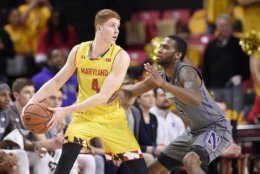 Maryland guard Kevin Huerter, left, handles the ball against Northwestern forward Vic Law, right, during the first half of an NCAA basketball game, Saturday, Feb. 10, 2018, in College Park, Md. (AP Photo/Nick Wass)