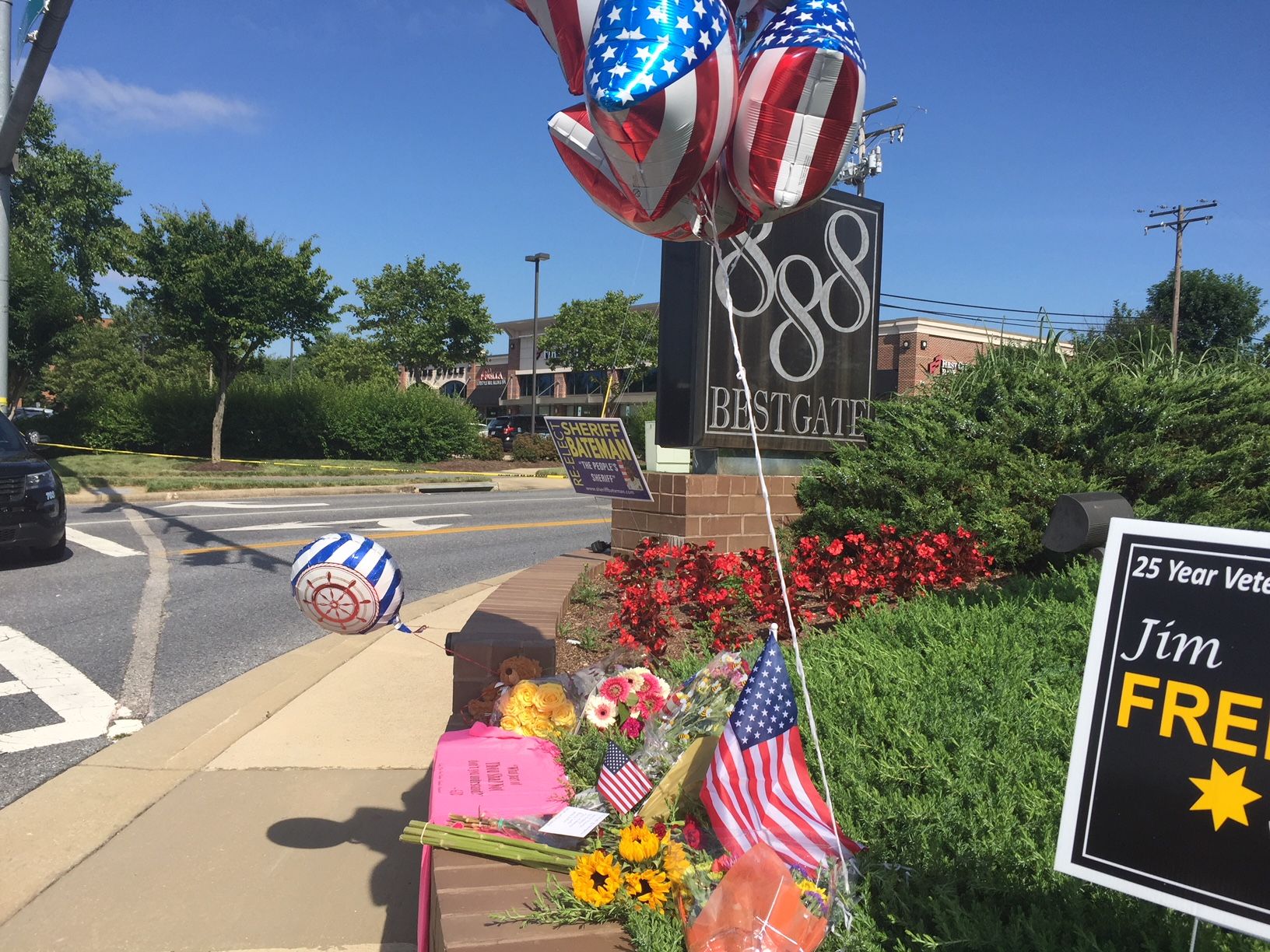 Flowers, balloons, cards and other gifts are seen outside of 888 Bestgate Road in Annapolis, Maryland, where five people were killed by a gunman at the Capital Gazette newspaper (WTOP/John Domen)