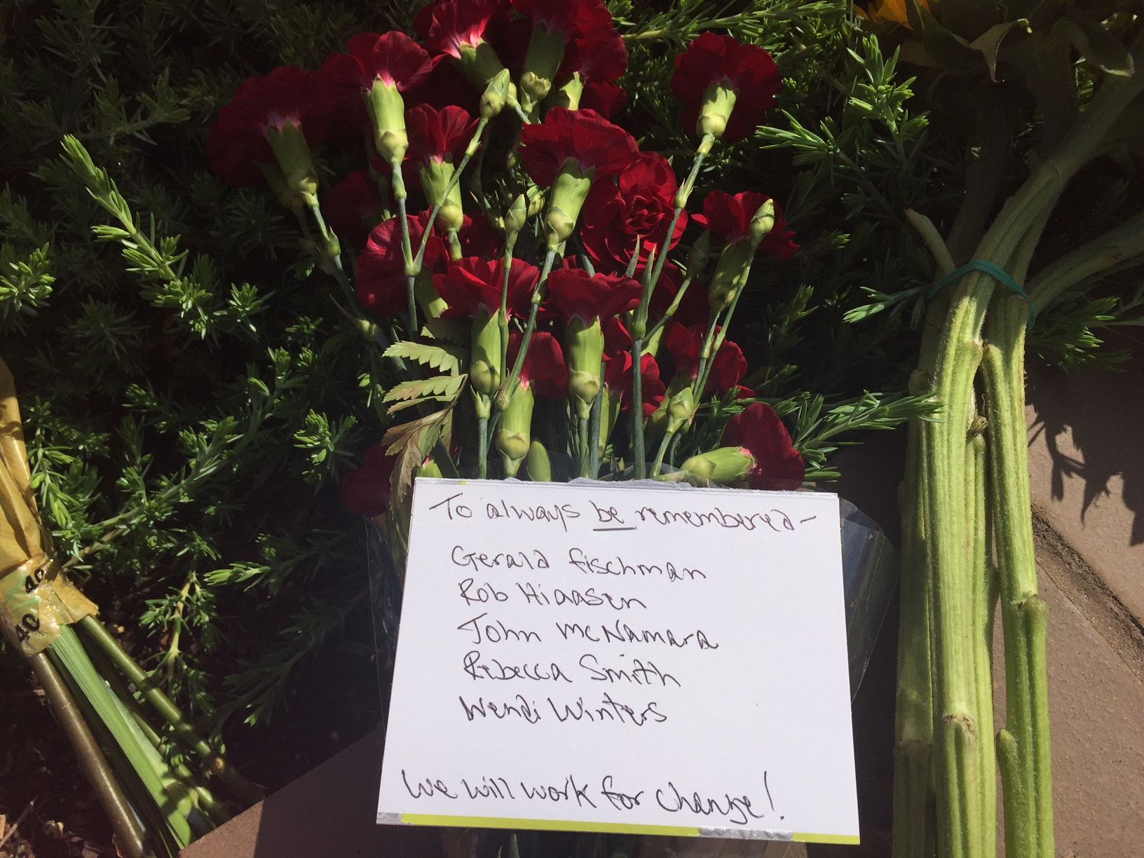 A note is seen at a memorial outside of the building where five people were killed at the Capital Gazette newspaper in Annapolis. (WTOP/John Domen)