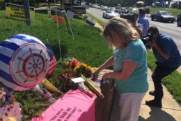 A woman is seen placing a note at a memorial in Annapolis for the victims of the shooting at the Capital Gazette newspaper. (WTOP/John Domen) 