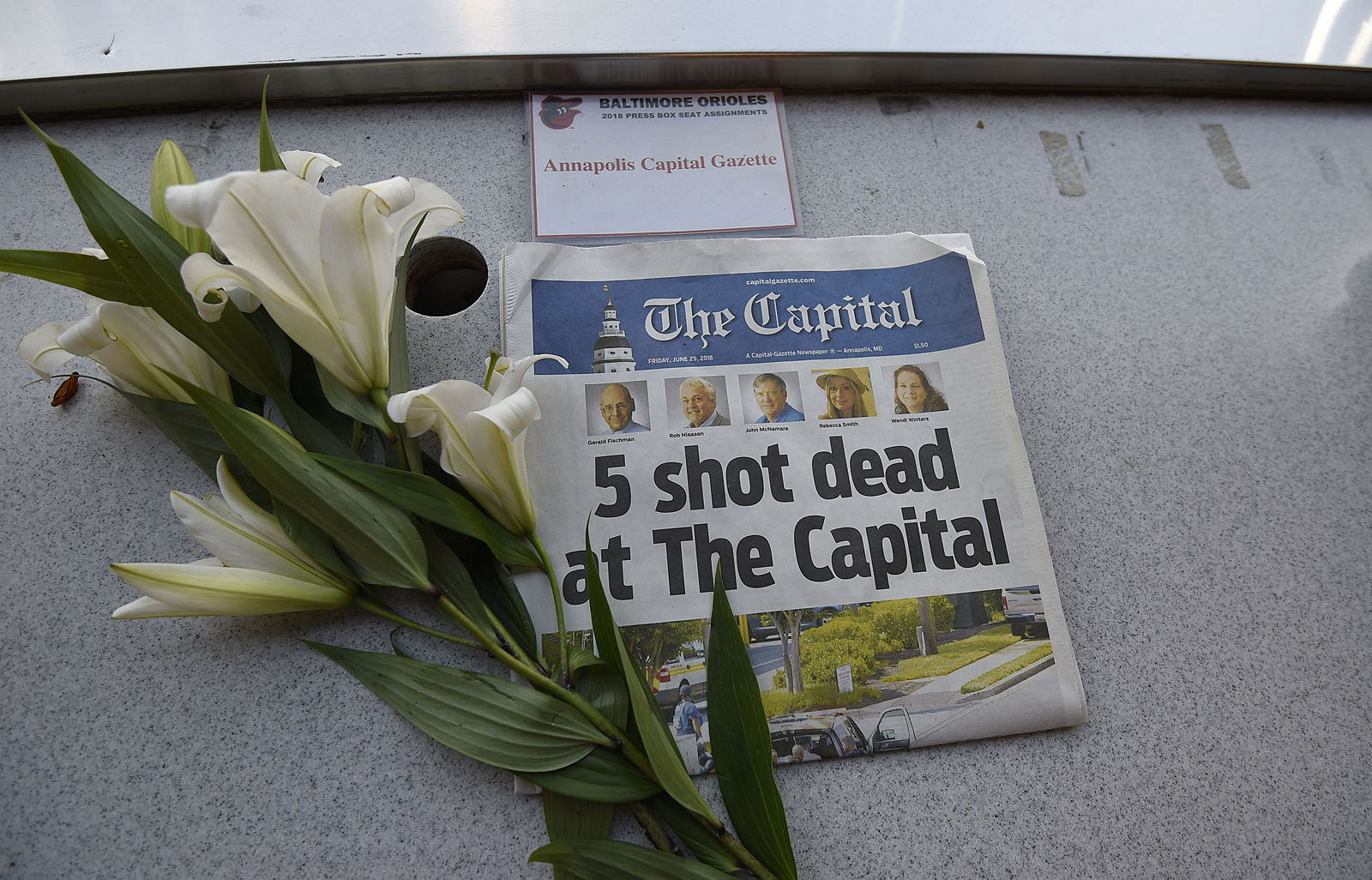 A memorial for Capital Gazette sports writer John McNamara is displayed at a seat in the press box before a baseball game between the Baltimore Orioles and the Los Angeles Angels, Friday, June 29, 2018, in Baltimore. McNamara is one of five victims in a  shooting in the newspaper's newsroom Thursday in Annapolis, Md. (AP Photo/Gail Burton)