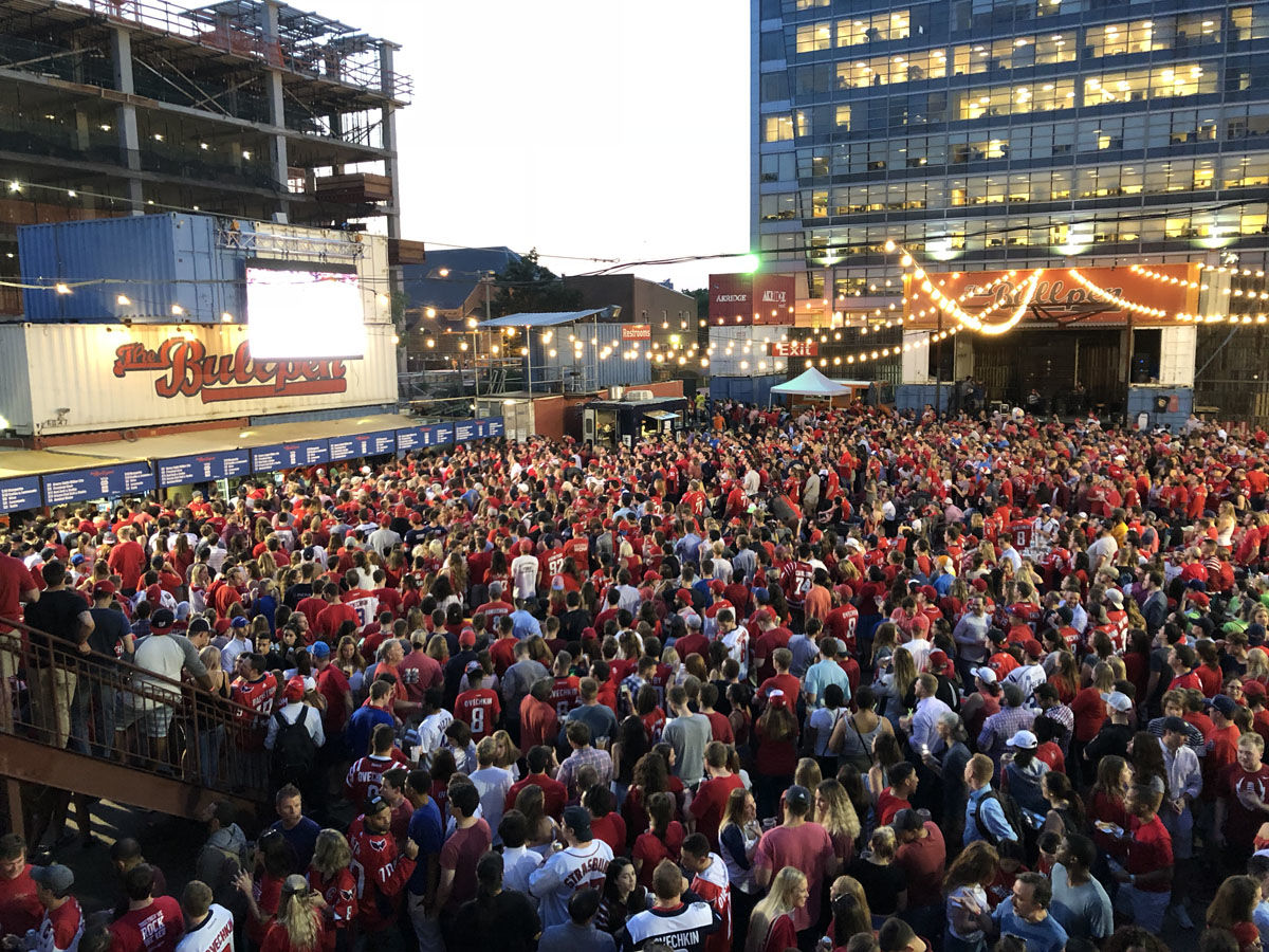 A sea of people watch the outdoor screen at The Bullpen near Nationals Park. (WTOP/Dan Friedell)