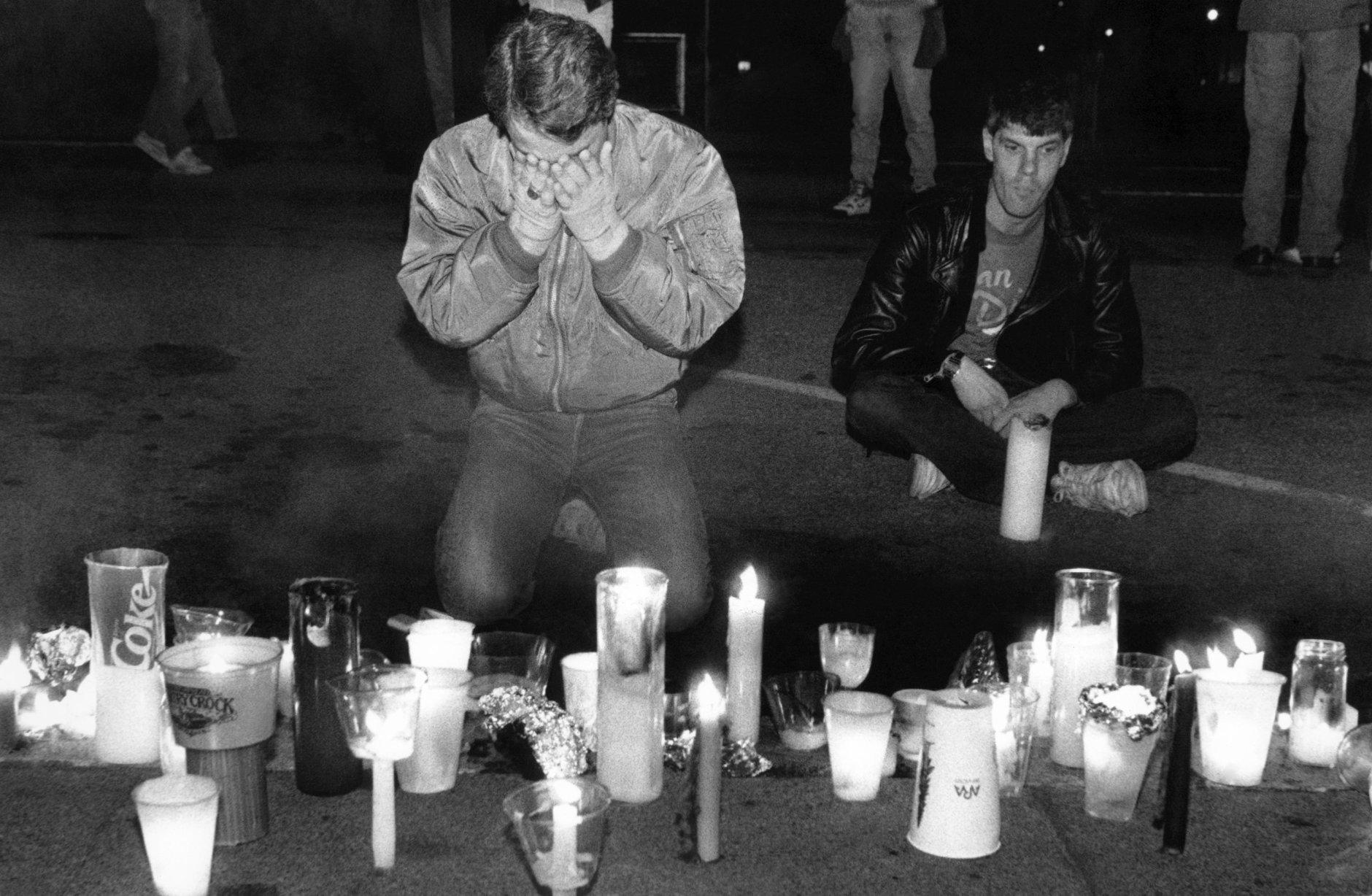 FILE - In this May 21, 1990 file picture, Scotty McQuown of San Francisco, left, weeps in front of a makeshift memorial to AIDS victims during the seventh annual International AIDS Candlelight Memorial in San Francisco. Up to 20,000 people gathered in front of San Francisco's City Halll to remember those lost to the disease and those still fighting it. Sunday, June 5, 2011 marks 30 years since the first AIDS cases were reported in the United States. Nearly 30 million people have died of AIDS since the first five cases were recognized in Los Angeles in 1981. About 34 million people have HIV now, including more than 1 million in the United States. (AP Photo/Bill Beattie)