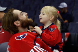 Washington Capitals goaltender Braden Holtby holds his daughter Belle Holtby on the ice after the Capitals NHL hockey team posed for a team picture with the Stanley Cup on the ice at Capital One Arena. (AP Photo/Alex Brandon)