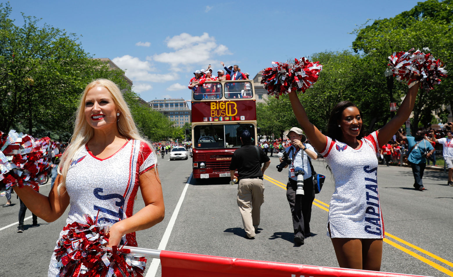 Ice girls lead the bus along the parade route. (AP Photo/Pablo Martinez Monsivais)