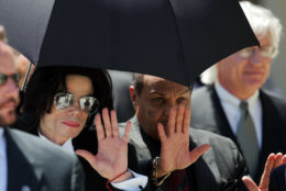 Michael Jackson waves as he leaves court with his father Joe, center, and his attorney, Thomas Mesereau Jr., far right, Monday, June 13, 2005, in Santa Maria, Calif. Jackson was found not guilty of all counts against him. (AP Photo/Mark J. Terrill)