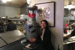 Fernanda Bernardes, of Graffiato DC, with a blow-up replica of the Stanley Cup ... and an Ovechkin beard. (WTOP/Liz Anderson)