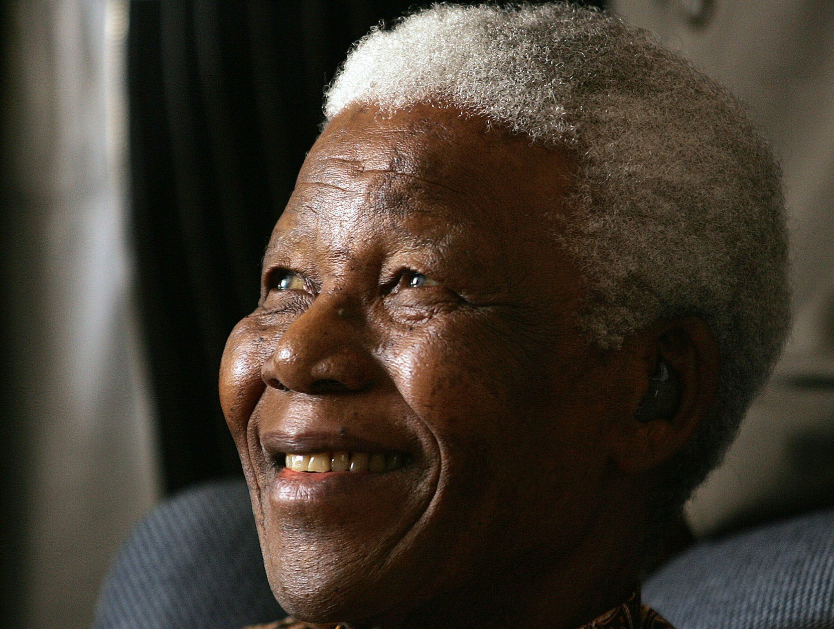 Former South African President Nelson Mandela smiles during his meeting with a group of Mandela Rhodes Scholars for 2006, in Johannesburg, South Africa, Tuesday, Jan. 31, 2006. Mandela, fresh from a two-week holiday in Mauritius,  was in high spirits when he met the 15 students chosen to benefit from a scholarship of which he is the patron. (AP Photo/Themba Hadebe)
