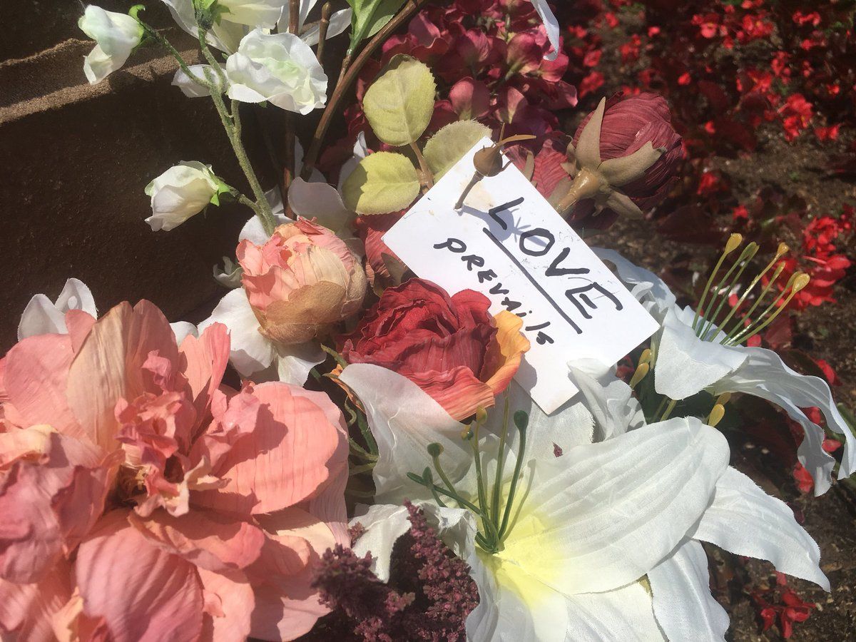 Flowers with a note "love prevails" are seen at a memorial outside of the Capital Gazette newsroom in Annapolis after five people were killed by a gunman (WTOP/Mike Murillo)