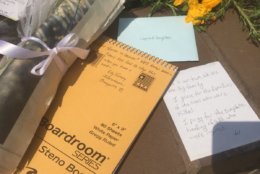 A press notebook, cards and gifts are seen at a memorial outside of the Capital Gazette where five people were killed by a gunman. (WTOP/Mike Murillo)