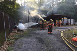 Firefighters also cool down a nearby fuel tank hose that was releasing gas out of the valve during a fire at Seneca Creek State Park on Saturday, June 16, 2018. (Courtesy Montgomery County Fire and EMS)