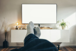 POV-Shot from a young watching tv with his feets and socks at home, including copy space. ideal for websites and magazines layouts