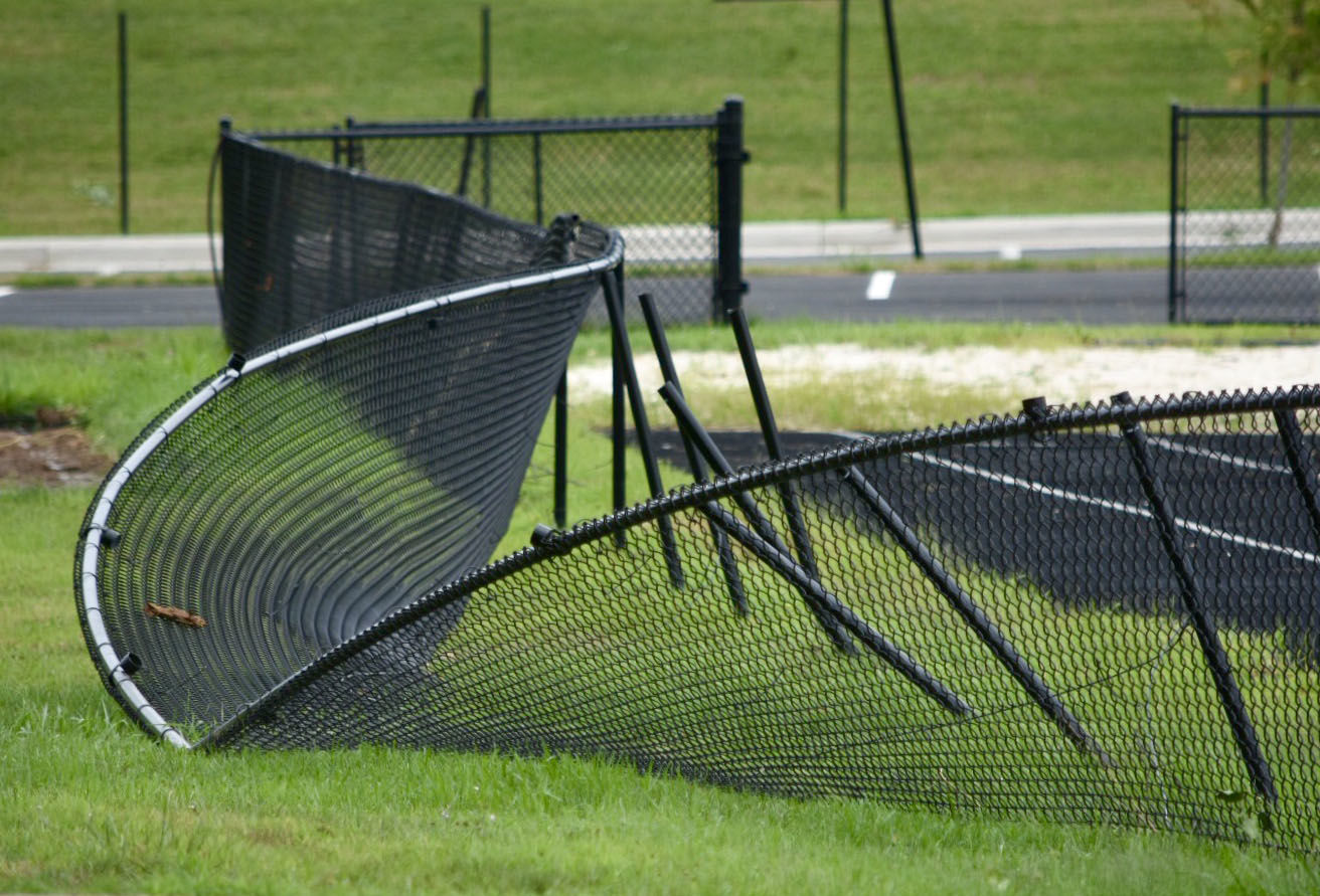 A warped fence is seen near Thomas Jefferson High School July 25, 2018. An EF-0 tornado briefly touched down early in the morning July 24, damaging several trees and two sheds. (WTOP/Dave Dildine)