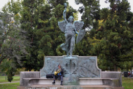 Victor Perpetua plays his French horn seated under a statue of the Spirit of Victory in Bushnell Park in Hartford, Conn., Tuesday, Oct. 23, 2012.  Perpetua is an attorney in the city and often comes out to the park to play his horn on his lunch break.  (AP Photo/Jessica Hill)