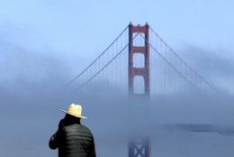 A man stands at China Beach as fog rolls past a span of the Golden Gate Bridge in San Francisco, Thursday, Sept. 28, 2017. (AP Photo/Jeff Chiu)