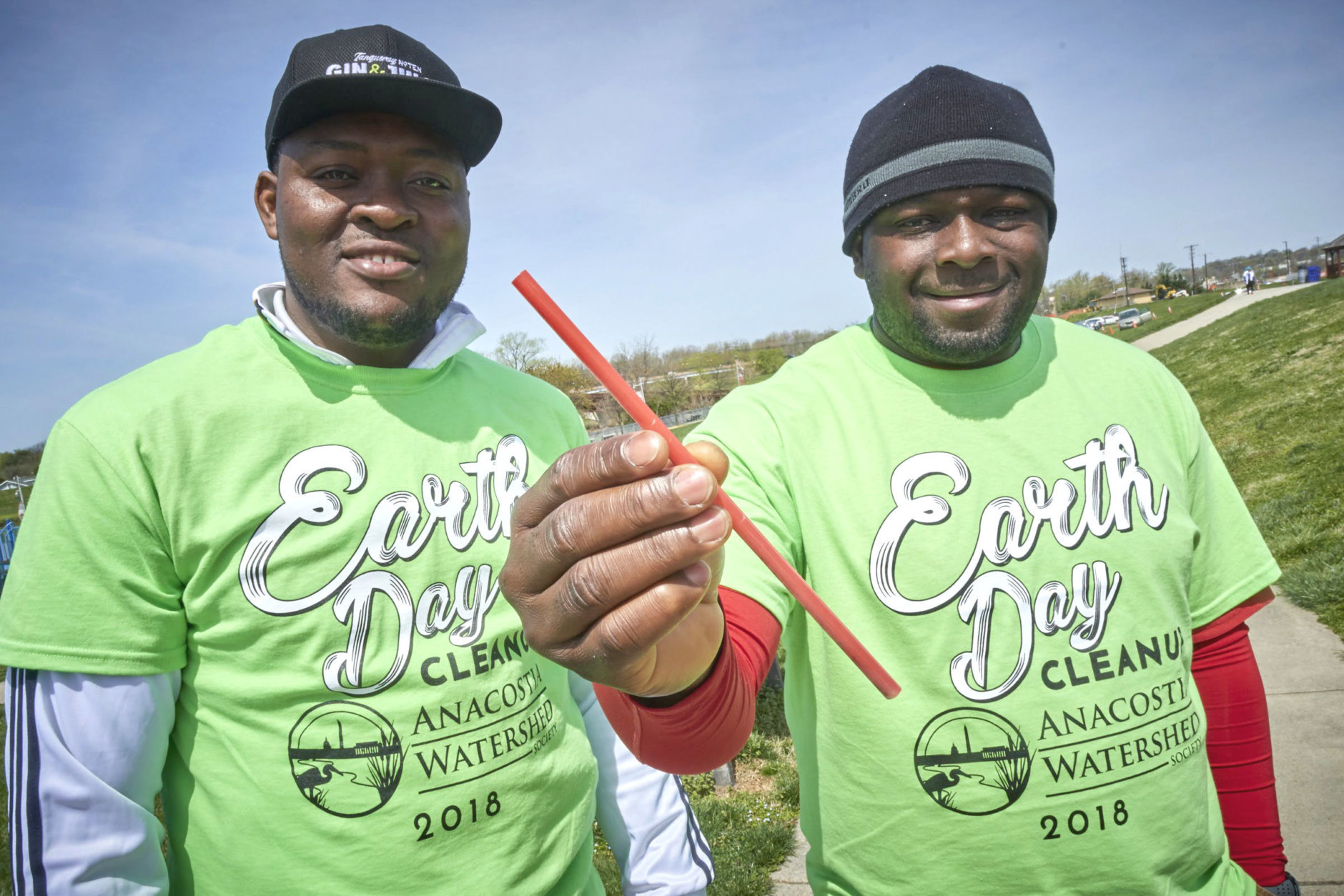 Volunteers at Bladensburg Waterfront Park hold up a straw they collected during the Anacostia Watershed Society Earth Day Cleanup. (Courtesy Dwayne Grimes/Anacostia Watershed Society)