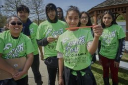 Young volunteers pose with a straw they cleaned up at the Earth Day event. (Courtesy Dwayne Grimes/Anacostia Watershed Society)