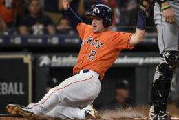 Houston Astros' Alex Bregman, left, scores during the third inning of the team's baseball game against the Chicago White Sox, Friday, July 6, 2018, in Houston. (AP Photo/Eric Christian Smith)