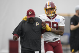 Washington Redskins running back Derrius Guice (29) jokes around with a coach during an NFL football team practice, Wednesday, June 13, 2018, in Ashburn, Va. (AP Photo/Nick Wass)