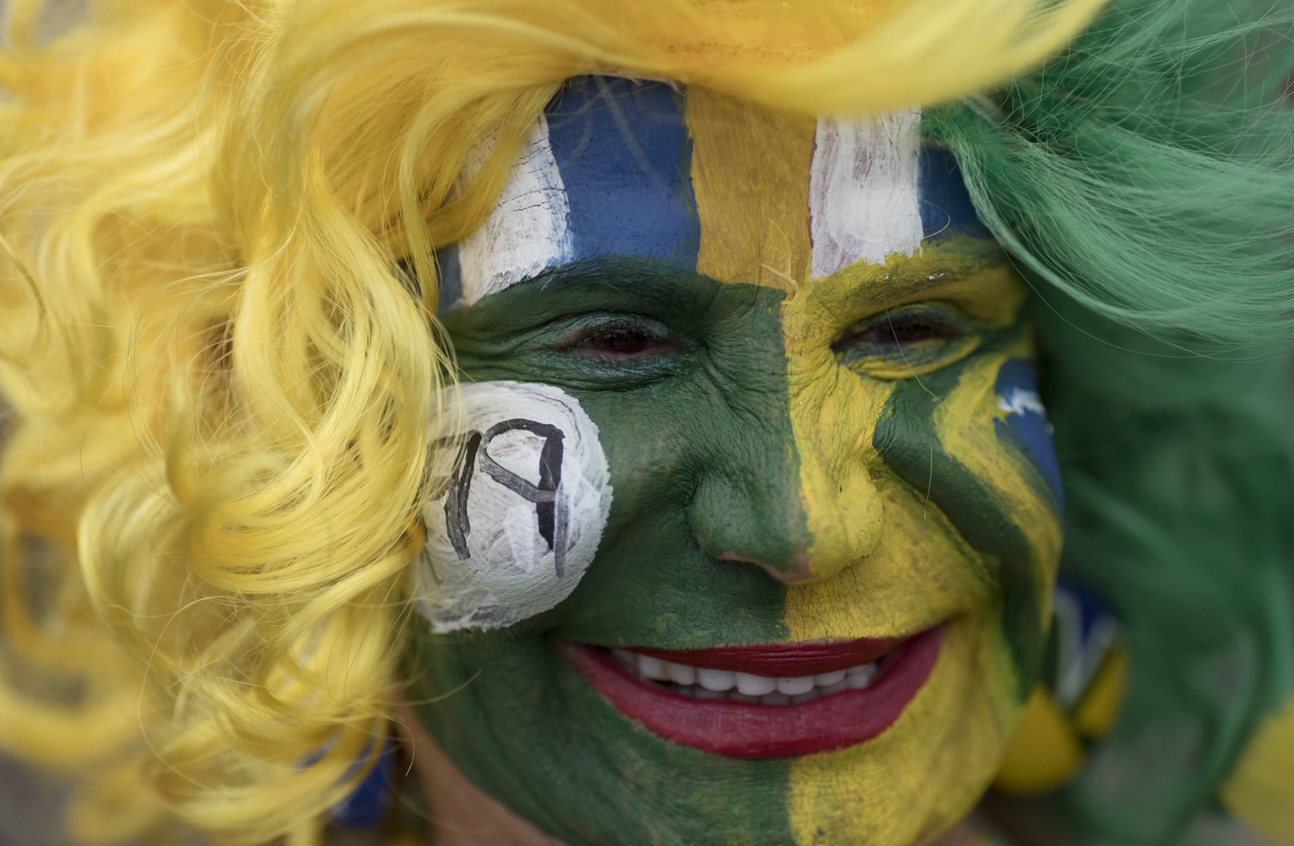 A Brazil soccer fan in costume waits for the start of a live broadcast of a 2018 Russia World Cup soccer match between Brazil and Mexico in Rio de Janeiro, Brazil, Monday, July 2, 2018. (AP Photo/Leo Correa)