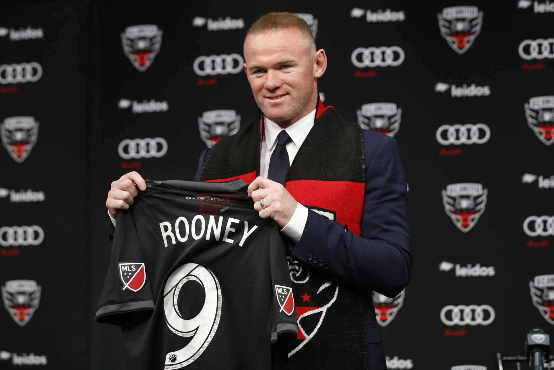 English soccer star Wayne Rooney, the all-time leading scorer for England's national team and Manchester United in the Premier League, poses with his new jersey during a news conference announcing his signing with MLS team D.C. United, Monday, July 2, 2018, at the Newseum in Washington. (AP Photo/Jacquelyn Martin)