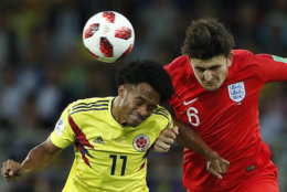 Colombia's Juan Cuadrado, left, and England's Harry Maguire challenge for the ball during the round of 16 match between Colombia and England at the 2018 soccer World Cup in the Spartak Stadium, in Moscow, Russia, Tuesday, July 3, 2018. (AP Photo/Alastair Grant)
