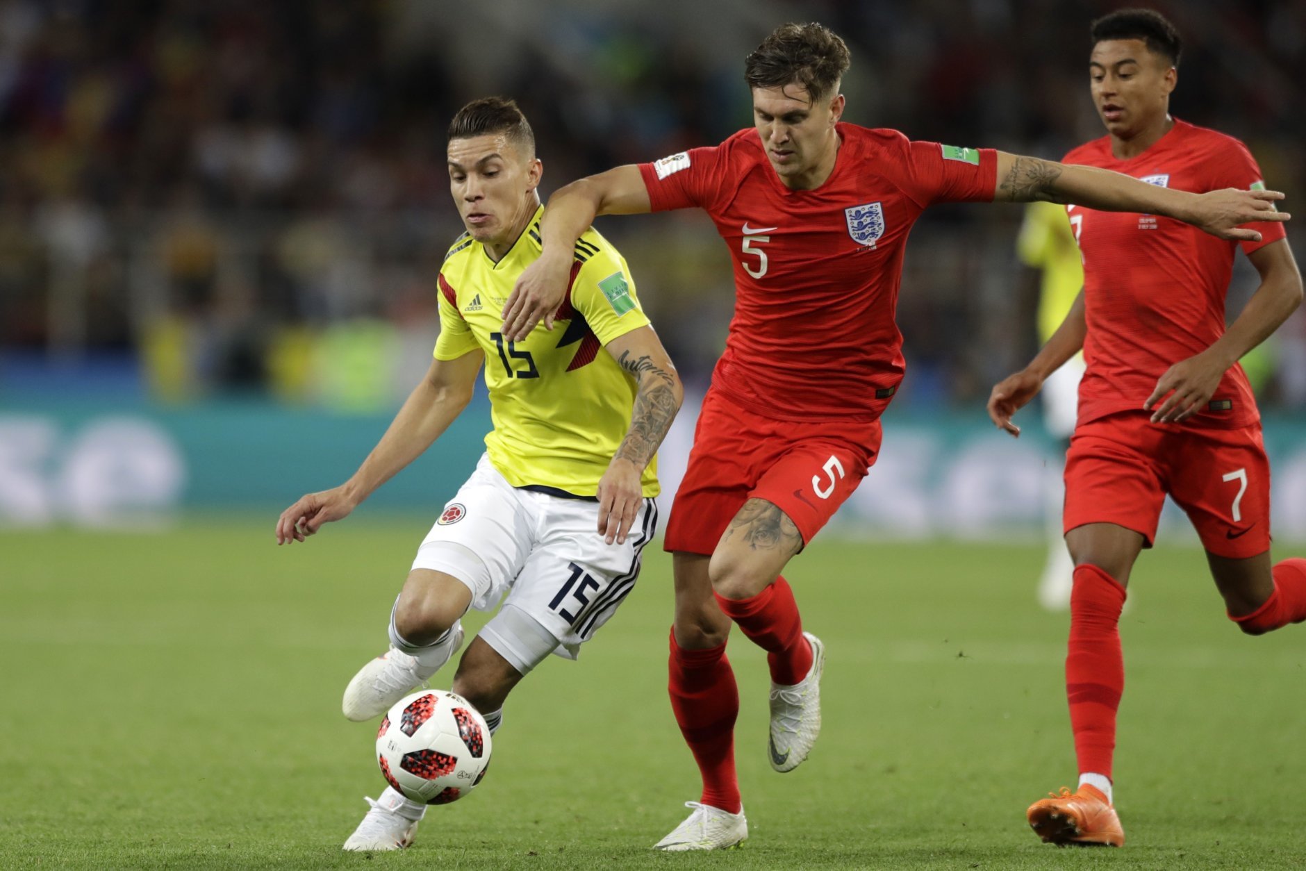 Colombia's Mateus Uribe, left, and England's John Stones fight for the ball during the round of 16 match between Colombia and England at the 2018 soccer World Cup in the Spartak Stadium, in Moscow, Russia, Tuesday, July 3, 2018. (AP Photo/Matthias Schrader)