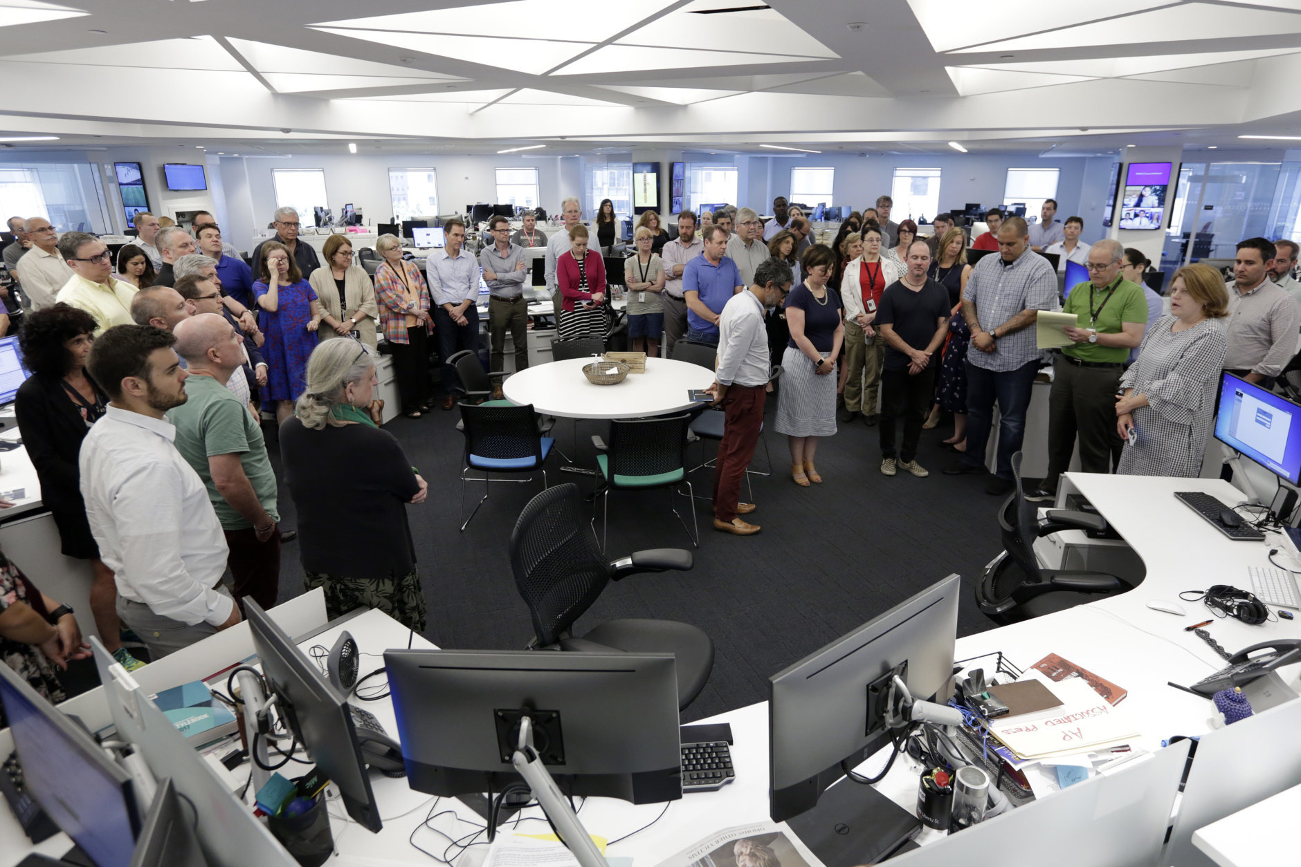 Employees gather in the newsroom of the New York headquarters of The Associated Press, Thursday, July 5, 2018, for a moment of silence for the five employees of the Capital Gazette, a Maryland newspaper, who were killed a week ago in one of the deadliest attacks on journalists in U.S. history. (AP Photo/Richard Drew)