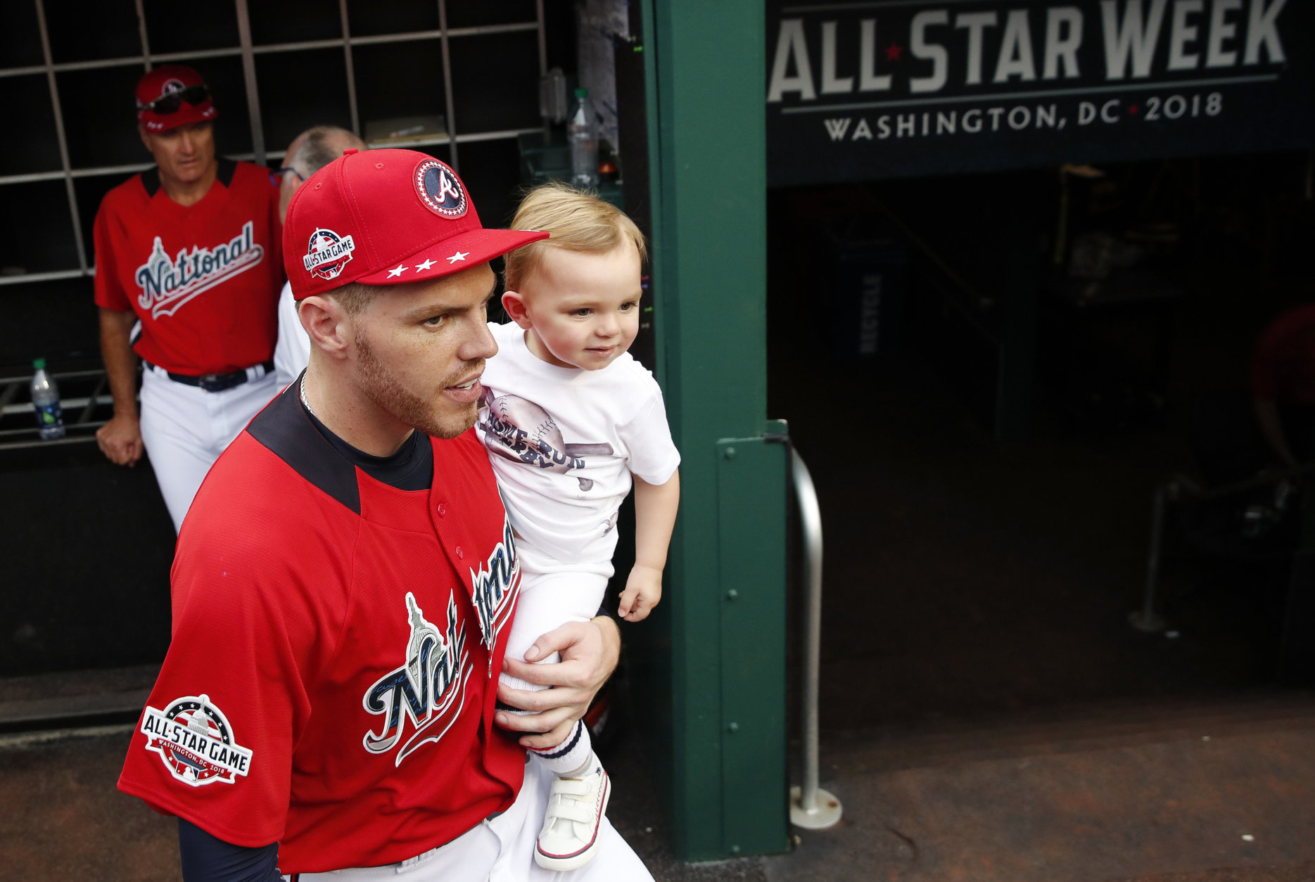 National League, Atlanta Braves Freddie Freeman holds his 22-month old child Charlie in the dugout during batting practice before the MLB Baseball Home Run Derby, at Nationals Park, Monday, July 16, 2018, in Washington. (AP Photo/Alex Brandon)