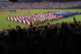 A choir moves on the field before the 89th MLB baseball All-Star Game, Tuesday, July 17, 2018, at Nationals Park, in Washington. (AP Photo/Carolyn Kaster)