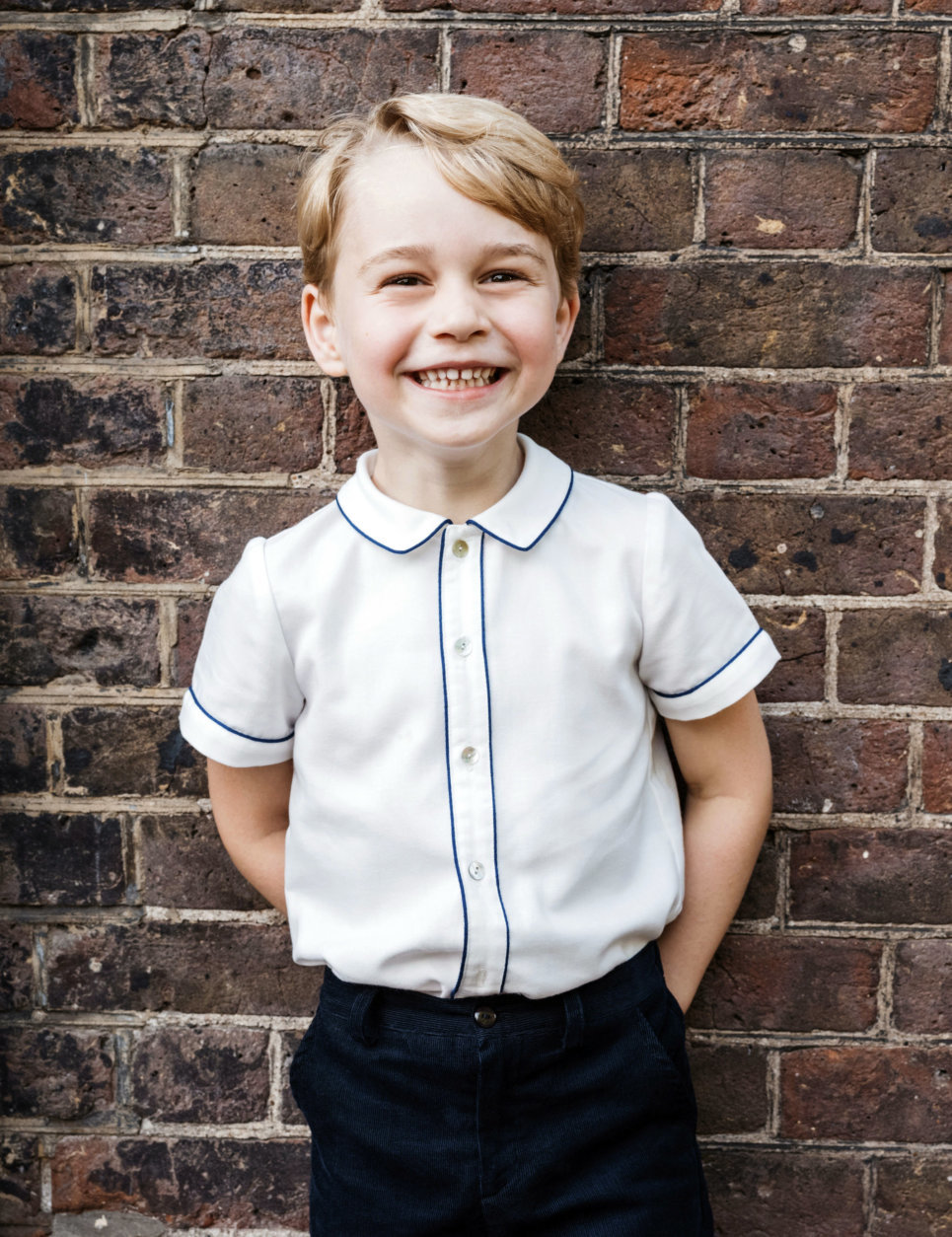 In this photo taken on Monday, July 9, 2018, Britain's Prince George poses for a picture following the christening of his brother Prince Louis, at Clarence House in London. Britain's Prince William and Kate, Duchess of Cambridge have released a photo of Prince George to mark his fifth birthday on Sunday, July 22. (Matt Porteous via AP)