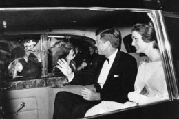 President John Kennedy and his wife Jacqueline smile as they drive through the gates of Buckingham Palace in London  June 5, 1961. They are to have dinner there with Queen Elizabeth II and Prince Philip. (AP Photo)